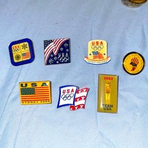 7 USA Olympic collectors pins from different years.